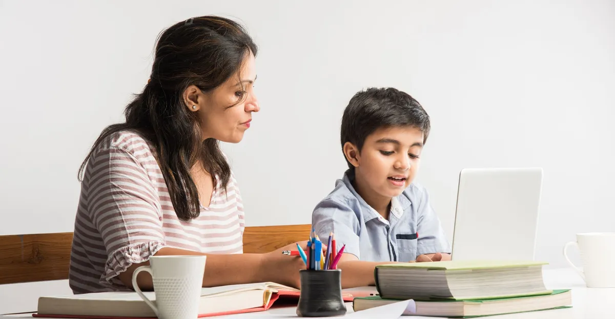 A mother helping her young son with his schoolwork