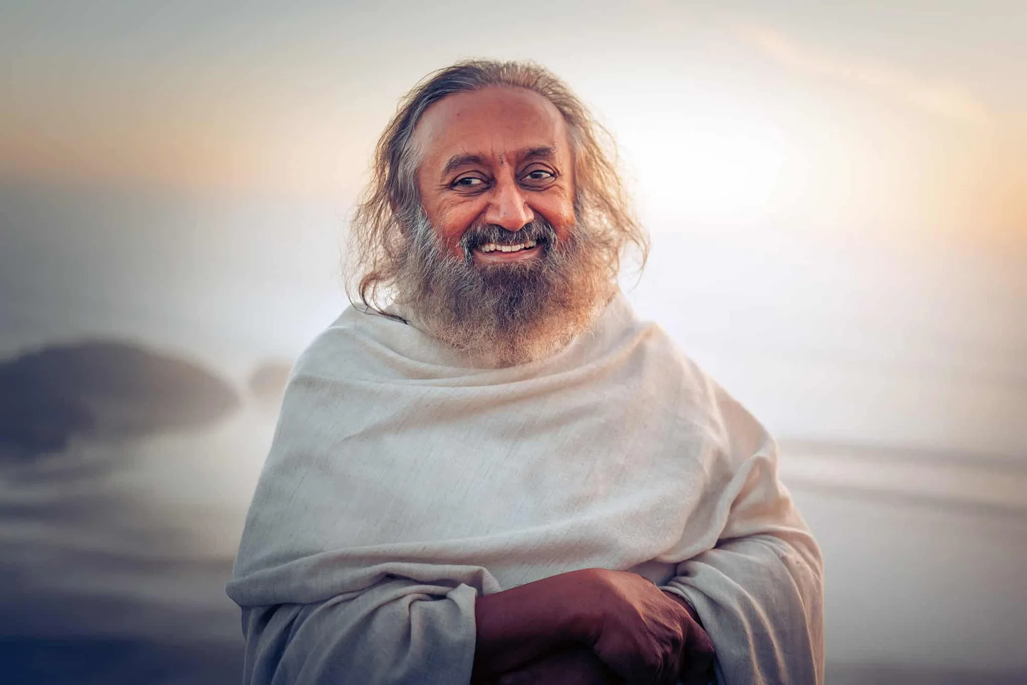 Gurudev Sri Sri Ravi Shankar smiling, wrapped in a white shawl