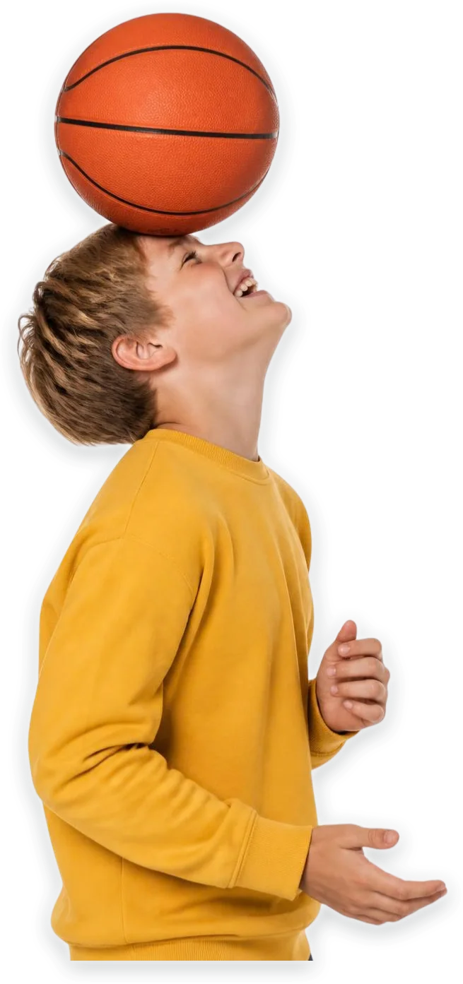 A laughing boy balancing a basketball on his forehead