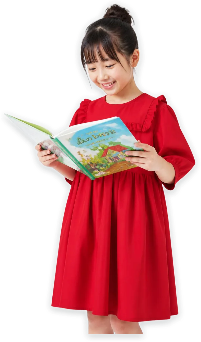 A girl in a red dress smiling as she reads a storybook