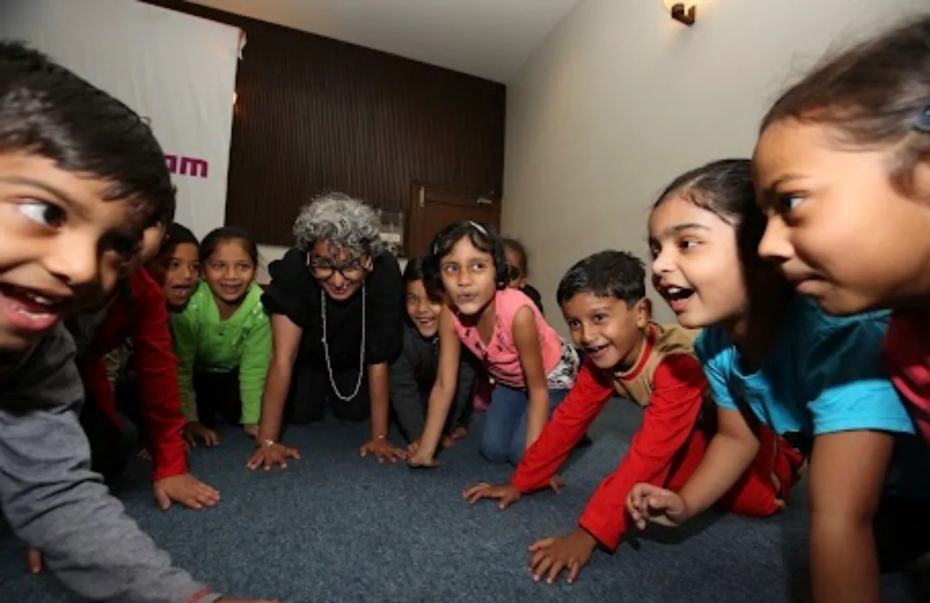 Shreya on the floor with a group of young children, mid-game