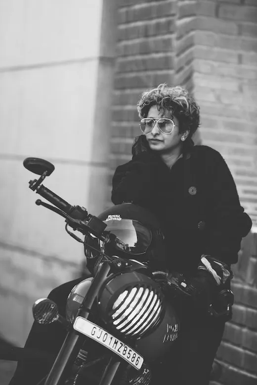 Shreya Chugh in sunglasses, sitting on a motorbike